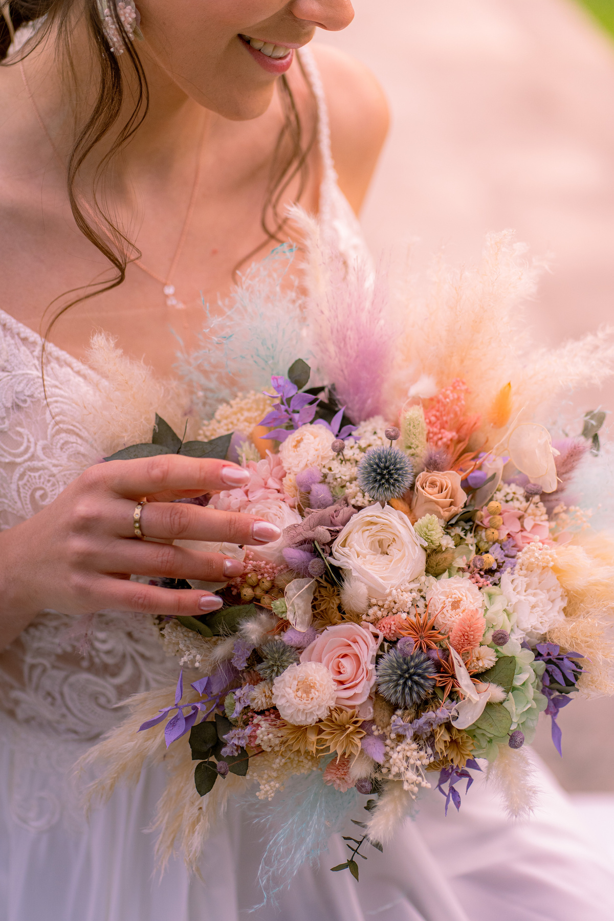 Zoom sur le bouquet de mariée en fleurs séchées et stabilisée de couleurs pastel : rose pale, mauve, jaune pâle et vert d'eau 
