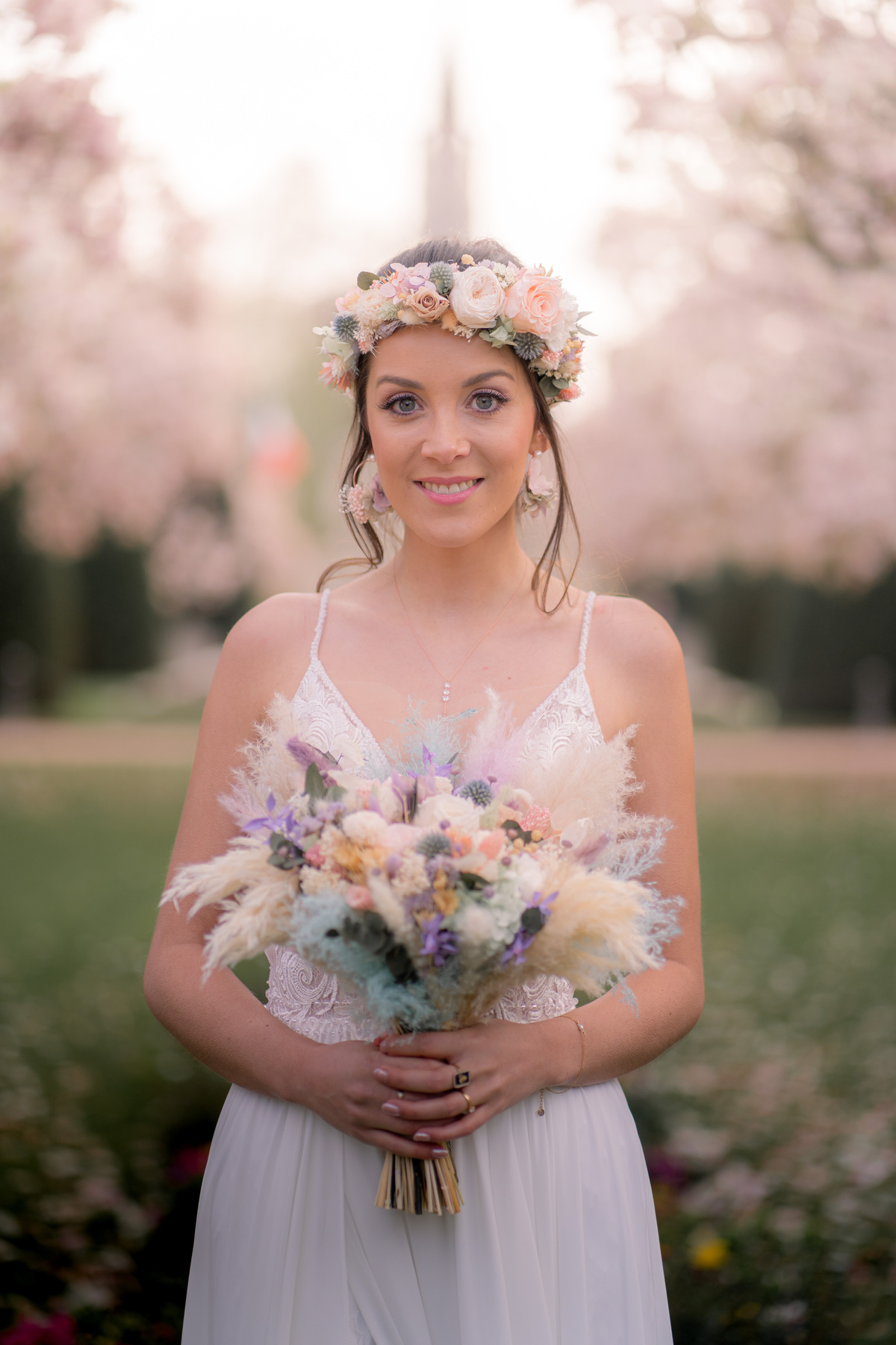 Portrait de la mariée avec bouquet de mariée en fleurs séchées et couronnes de fleurs en fleurs séchées. Les fleurs sont de couleurs pastels. 