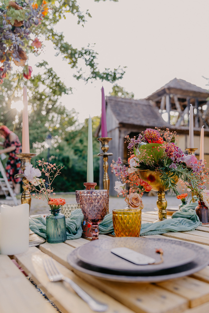 tables de mariage dressée. La table est en palette avec une décoration de table multicolore. 