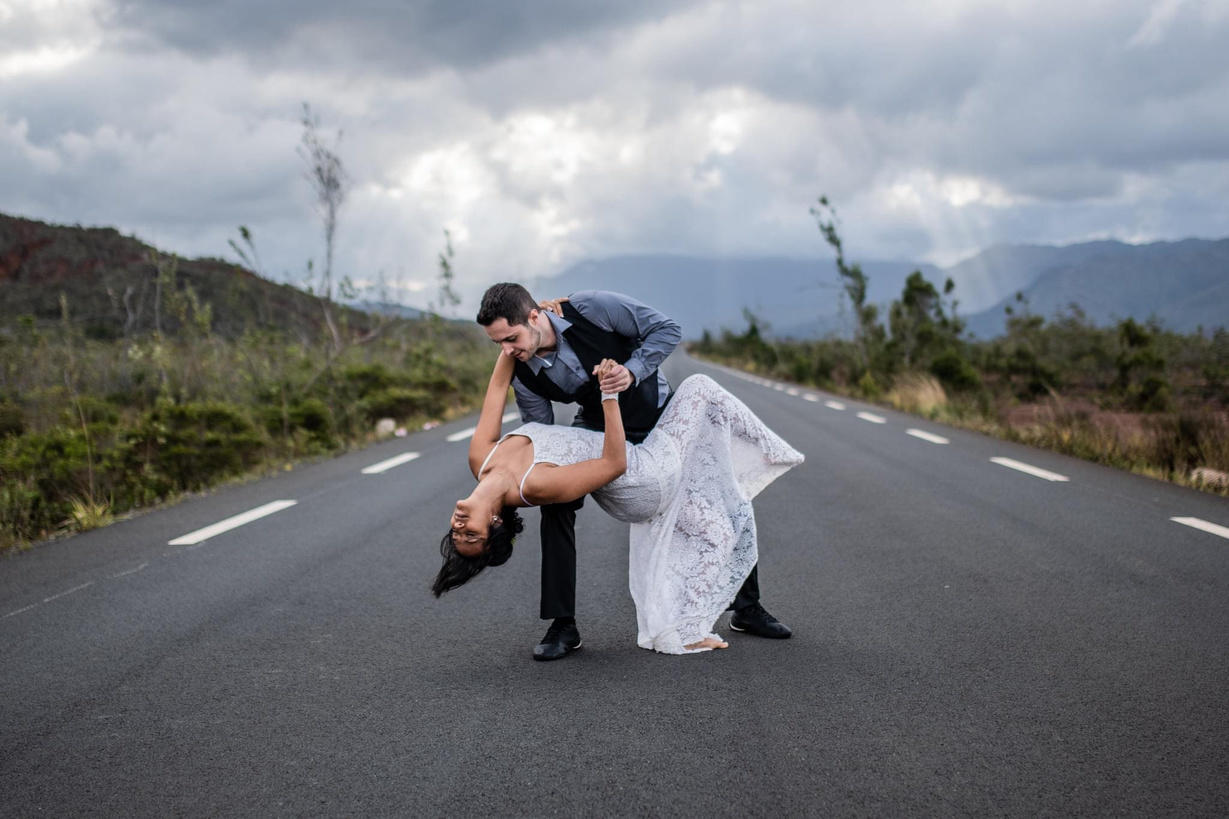 couple de mariés en train de danser sur la route